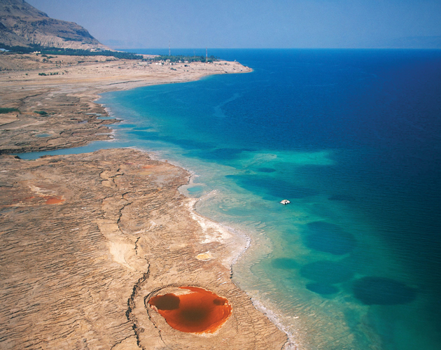 Mineral deposits create pools of color in the sun-bleached landscape of the Dead Sea.