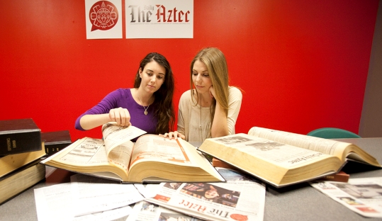 The Daily Aztec News Editor Tara Millspaugh and Photo Editor Paige Nelson review old issues of the paper. (Photo by Antonio Zaragoza)