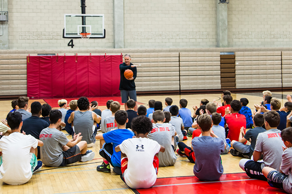 SDSU men's basketball head coach Brian Dutcher speaks to kids at basketball camp.