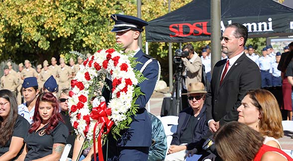 Military representatives, veterans and families gathered for SDSU Alumni's annual wreath-laying ceremony at the War Memorial on Aztec Green in 2019.