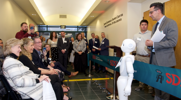 SDSU AI Lab Director Aaron Elkins (right) demonstrates humanoid AI robot Pepper for Marilyn Brown (left) during the Feb. 27 ceremony of the James Silberrad Brown Center for Artificial Intelligence.
