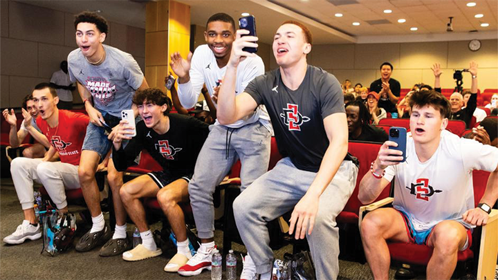 Members of SDSU men's basketball team celebrate upon learning they will be playing in the 2024 NCAA Tournament.