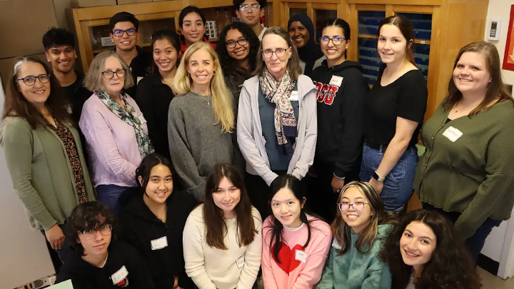 Four principal investigators at SDSU who manage the Biotech Scholars program pose for a photo in the lab with their cohort of fourteen undergraduate students