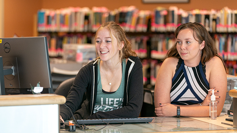 Two students looking at a laptop