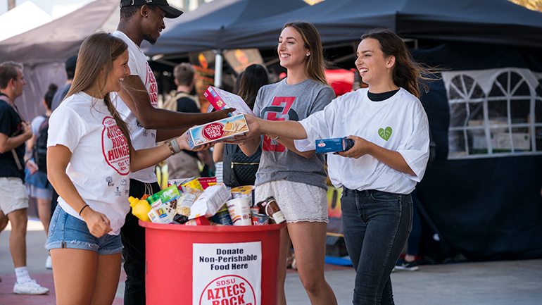 Students handing others food.