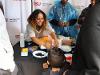 A volunteer from the National Society of Black Engineers SDSU chapter helps a young attendee create a color-coded bracelet.