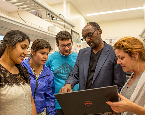 Professor showing students something on his laptop