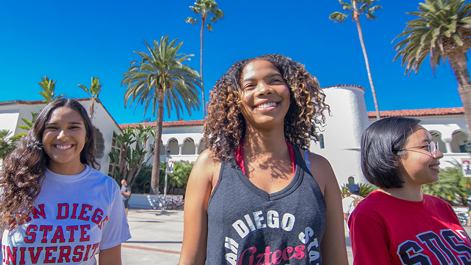 3 students walking on campus