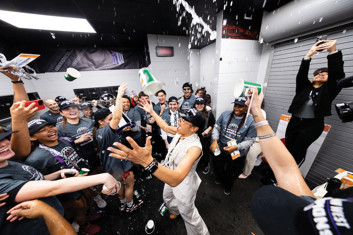 Women's basketball team celebrating their win in the locker room