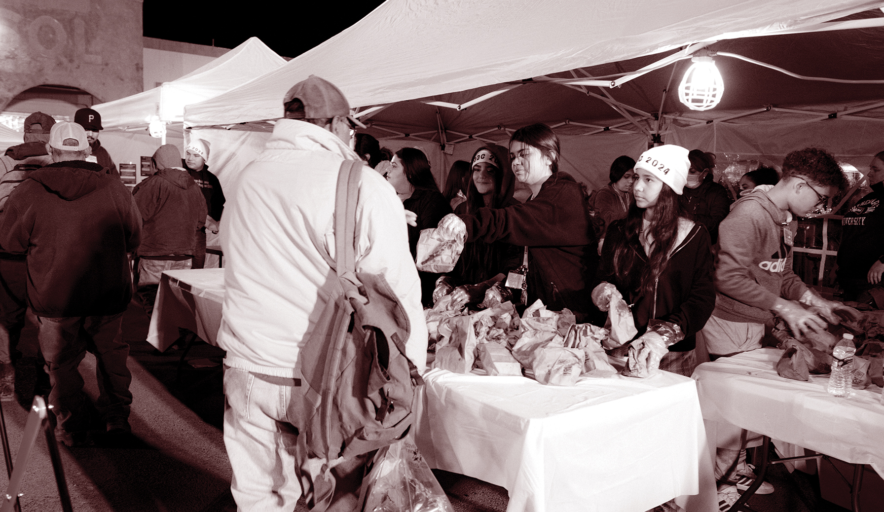 Volunteers at booths giving out complimentary bagged breakfasts, tamales and much-needed coffee