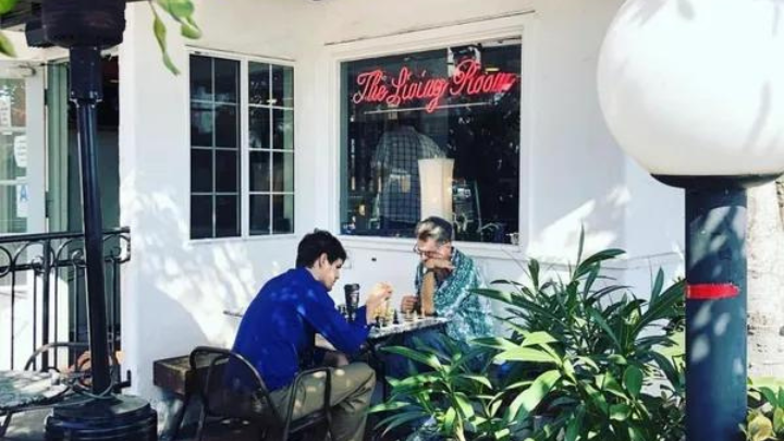 Living room cafe image of two people sitting together at a table.