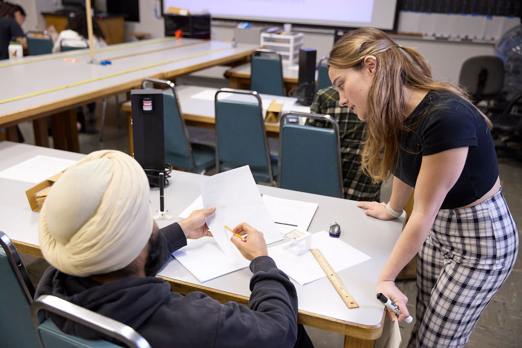 Women looking at a piece of paper that a man is holding up.