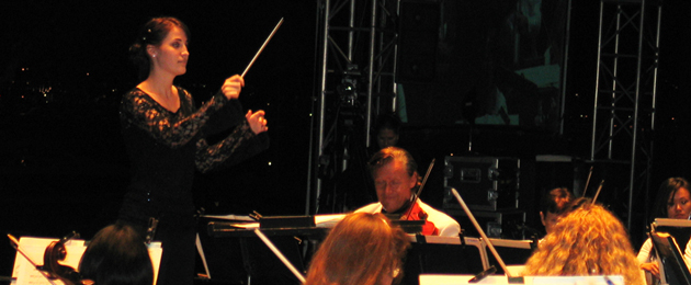 Sarah Davis, standing, conducts the San Diego Symphony.