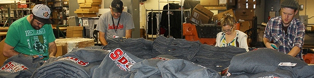SDSU Bookstore employees tag and sort a shipment of Poinsettia Bowl gear.