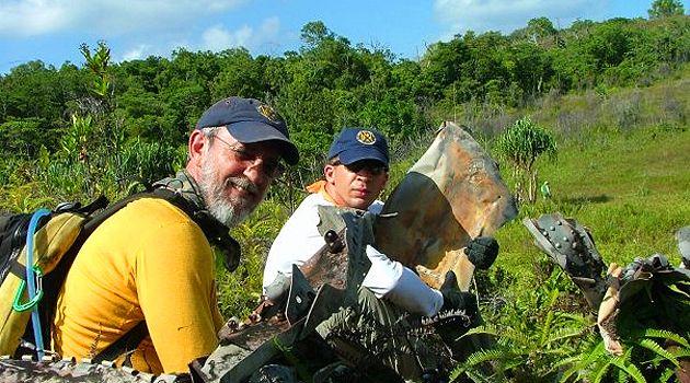 Abbey, right, and colleague pose with debris from a World War II aircraft
