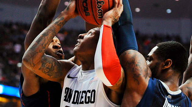 Billy White keeps two University of Connecticut defenders at bay in the team's 74-67 loss.
