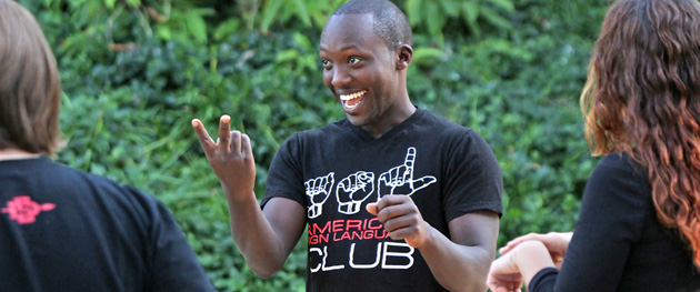 Isidore Niyongabo conversing in ASL with members of the SDSU ASL Club.