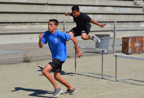 Hilltop High students sprint towards the finish in a hurdle race.