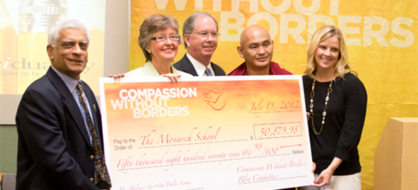 Lama Tenzin Dhonden, SDSU Provost Nancy Marlin and other local university representatives present a check to the Monarch School.