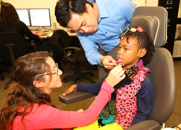 Professor Ignatius Nip and a student assistant prepare a child participant for motion capture speech-language testing.
