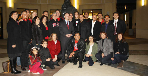 Members of La Plebe pose for a December 5 photo with SDSU President Elliot Hirshman in the rotunda of the Parma Payne Goodall Alumni Center.