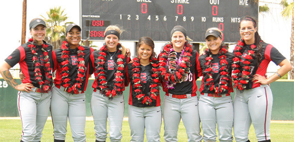 The women's softball team celebrates after a win.