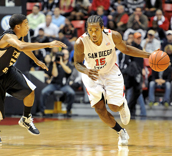 Kawhi Leonard dribbles past a defender across the court. (Photo: Ernie Anderson)