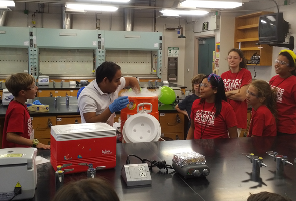 Physics student Gerardo Mendoza demonstrates the effect liquid nitrogen has on an inflated balloon.
