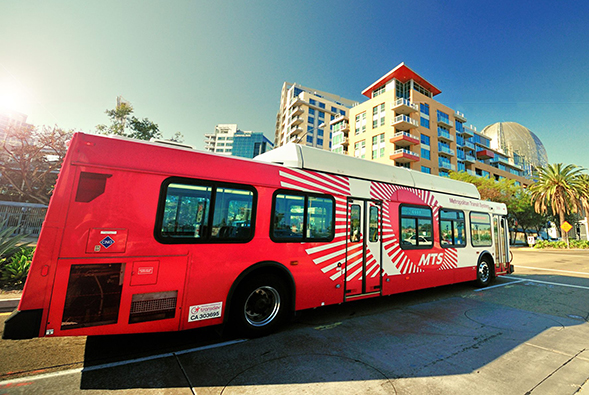 A Metropolitan Transit System bus drives on a city street in San Diego. (Credit: MTS)