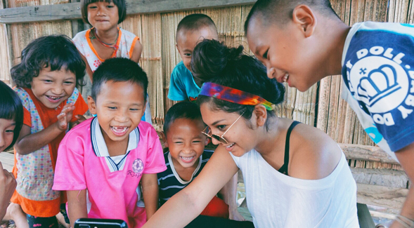 SDSU student Nicole Garcia playing with children while volunteering abroad.