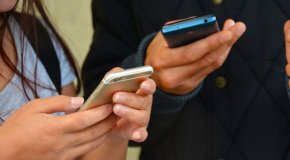 Teens looking at their smartphones