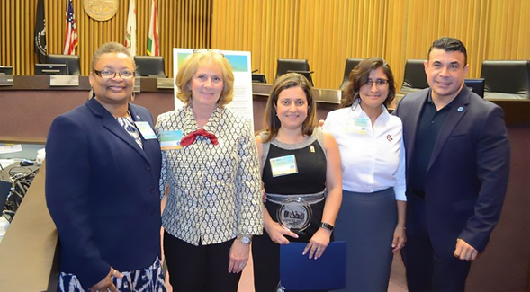 SDSU President Sally Roush (second from left) and Graduate School of Public Health Director Hala Madanat (center) accept the HHSA Director Award.