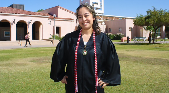 Graduating student Monique Ornelas with her commencement gown and Legacy Cord during Grad Night at SDSU-Imperial Valley.