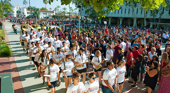 The SDSU marching band and cheerleaders lead the Band Run through campus.