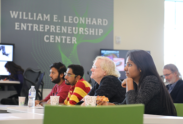 Leah Jamieson (center) listens as engineering students present research at the Women in STEM Series Seminar.