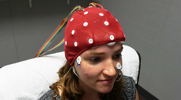 TraciAnn Hoglind, a researcher in the SDSU Laboratory for Language and Cognitive Neuroscience, demonstrates the EEG cap worn by study participants.