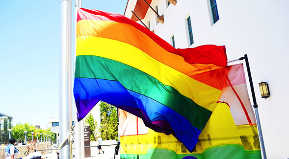 The Pride Flag flying adjacent to the Conrad Prebys Aztec Student Union