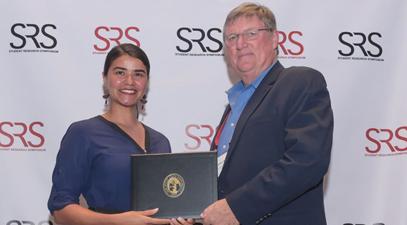 Maricruz Carillo, a doctoral student in engineering, receiving an award for her research on bone replacement techniques from Vice President of Research and Dean of Graduate Affairs Stephen Welter.