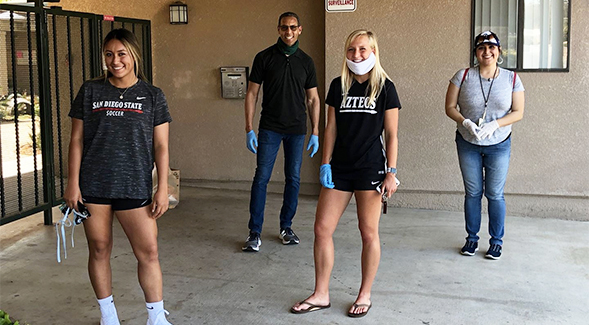 Veronica Avalos (left) and Abbie Rieder (second from right) deliver groceries to those in need during the COVID-19 pandemic.