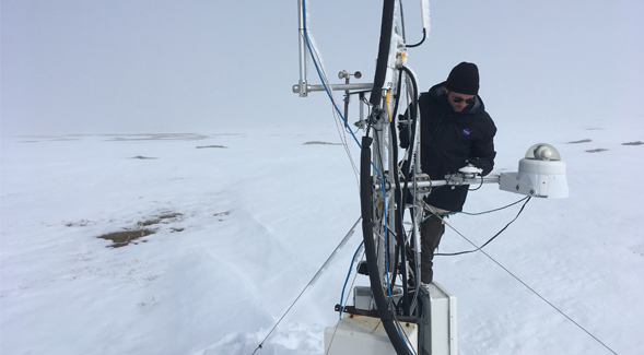 Ecosystem ecologist and post-doctoral fellow Kyle Arndt checking on the measurement equipment set up by SDSU in Utqiagvik (formerly Barrow), Alaska.