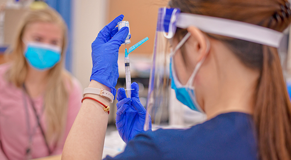 An SDSU nursing student prepares to vaccinate another student as part of training to volunteer to vaccinate the public. Photo: Frank Villalpondo