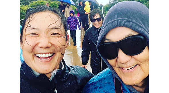 The Joh family (Tiffany and Gun-Ho with Oak in the background) braves the rain during a trip to Australia.