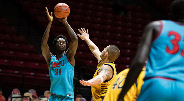 Turquoise is the team color for the annual N7 men's basketball game. Above, Aztecs forward Nathan Mensah took a shot in the 2020 game, conducted with no spectators.