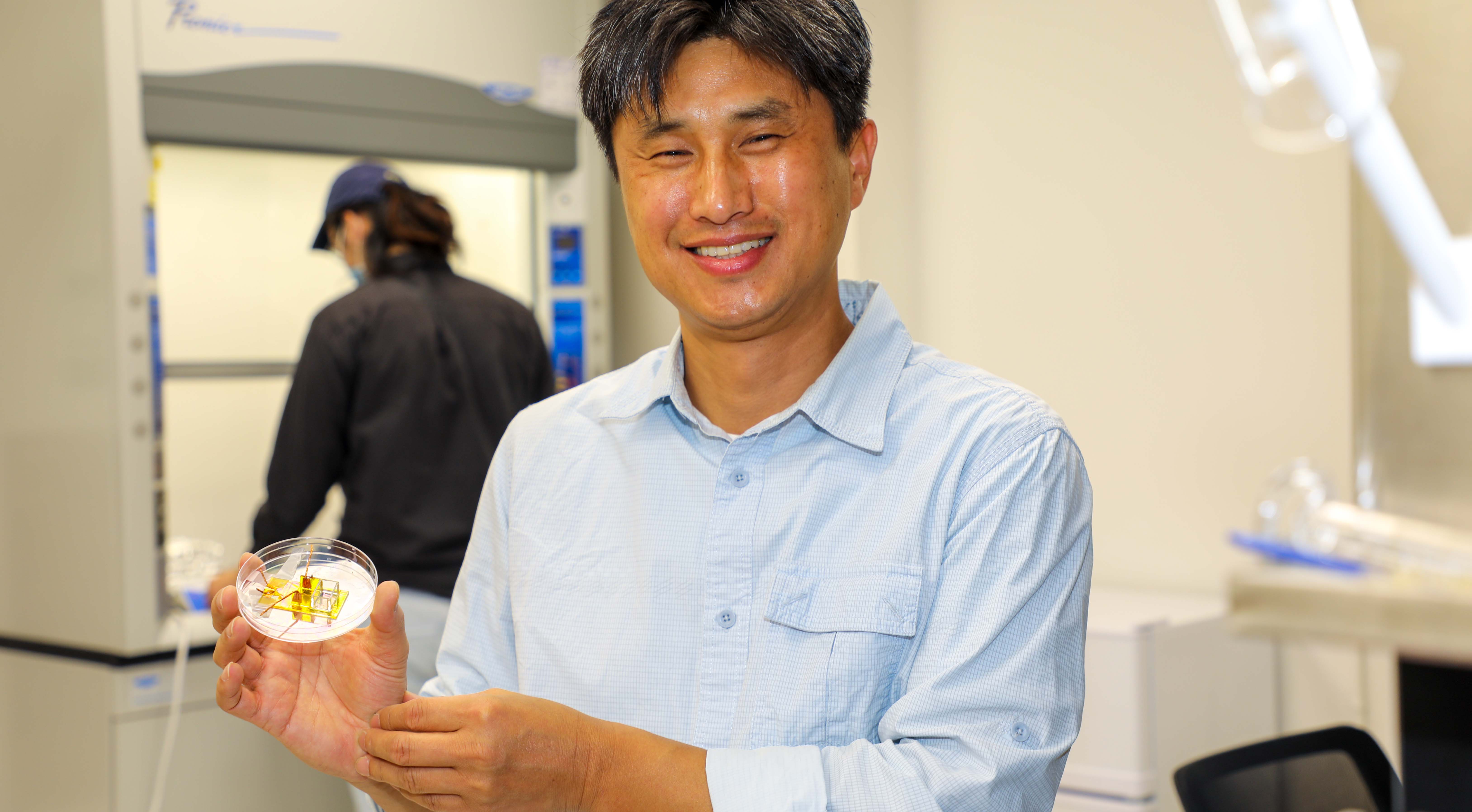 Sung-Yong (Sean) Park, in his Engineering lab, shows a petri dish containing his liquid prism, which controls the optofluidic process in his work. (Photo: Scott Hargrove)