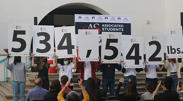 Students held up signs revealing that 534,542 pounds of food were raised.