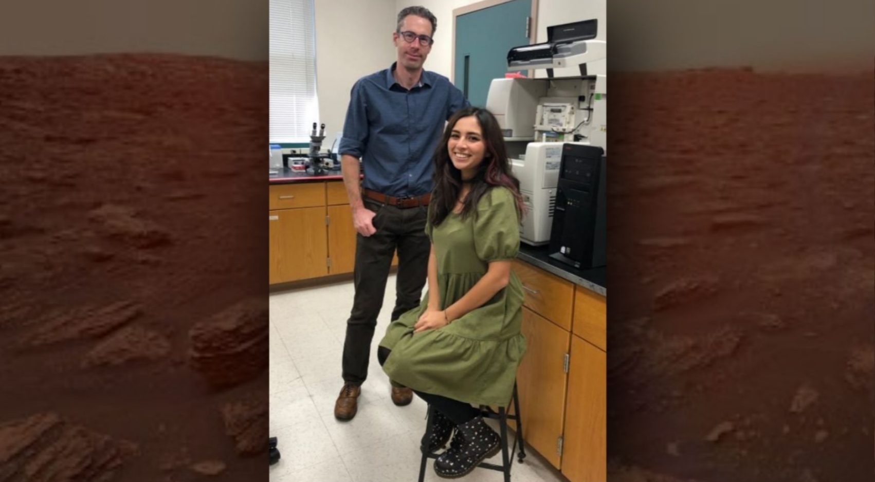 SDSU researchers Chris Harrison and Jessica Torres, seen above in Harrison's lab, are using lasers and liquids to detect amino acids in extraterrestrial rocks. In the background, an image of Mars.