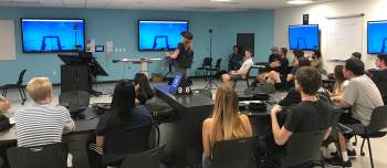 A student is pictured demonstrating a device at SDSU's new research center dedicated to expanding the use of emergent virtual technologies in the classroom.
