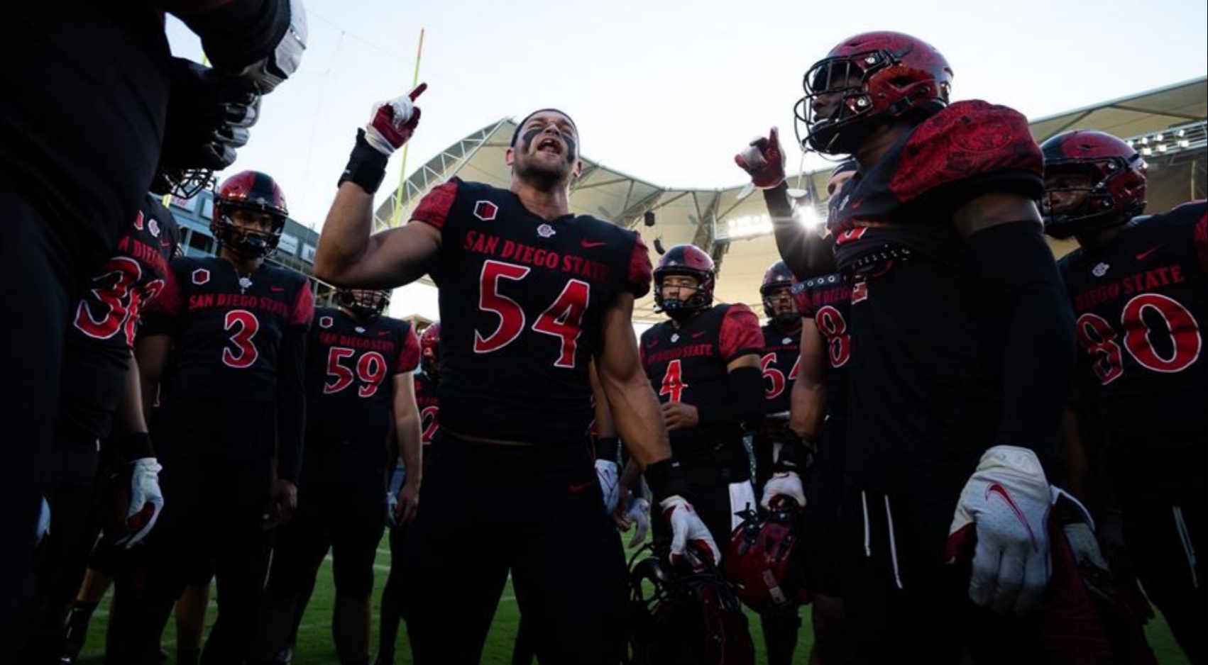 SDSU Aztec football players gather together during a game.