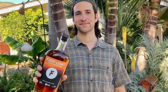 SDSU MBA student and First Light Coffee Whiskey co-founder, David Elizondo, poses with a bottle of his craft whiskey.