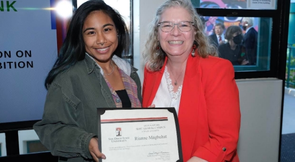 Rianne Magbuhat (left) is presented with the Global Campus Award during the twenty-fourth annual Art and Design Student Award Exhibition on March 3, 2022.
